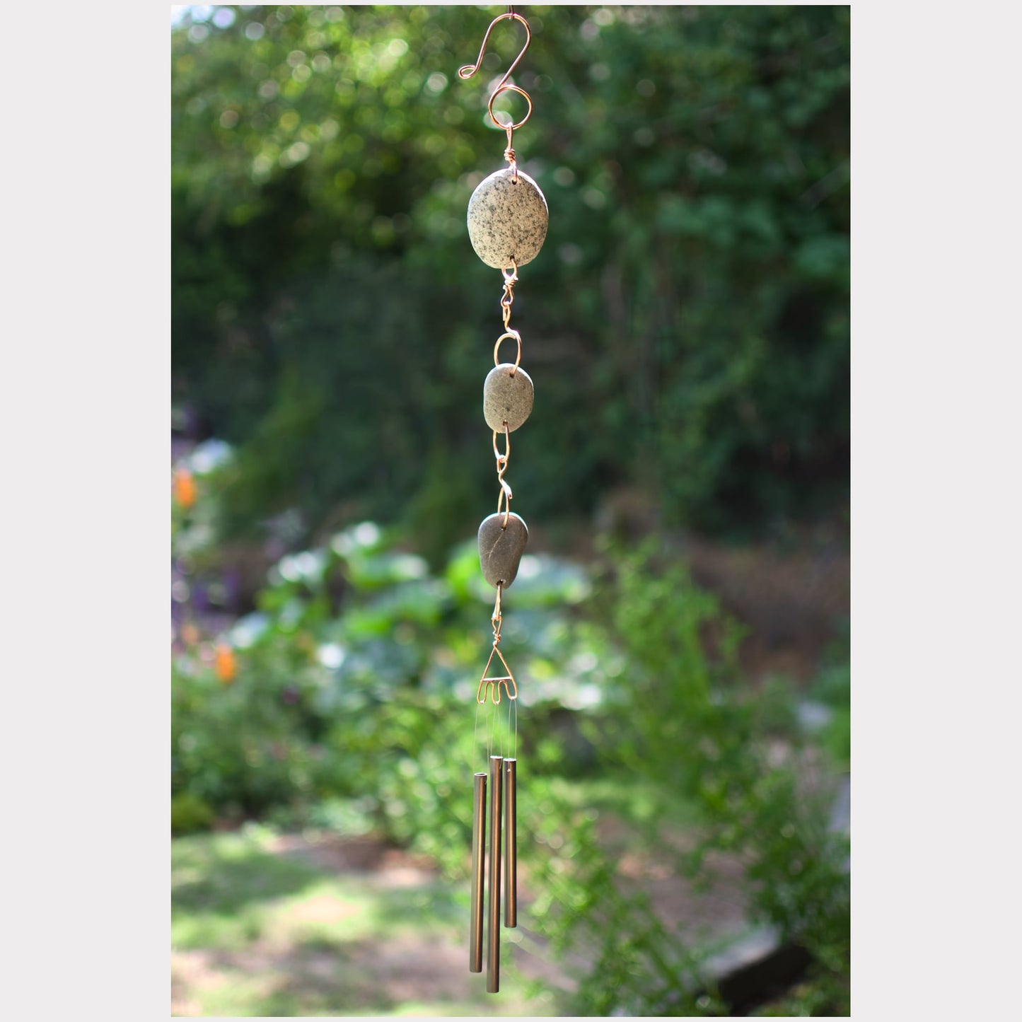 Handcrafted natural beach stone wind chime with three antiqued brass chimes.