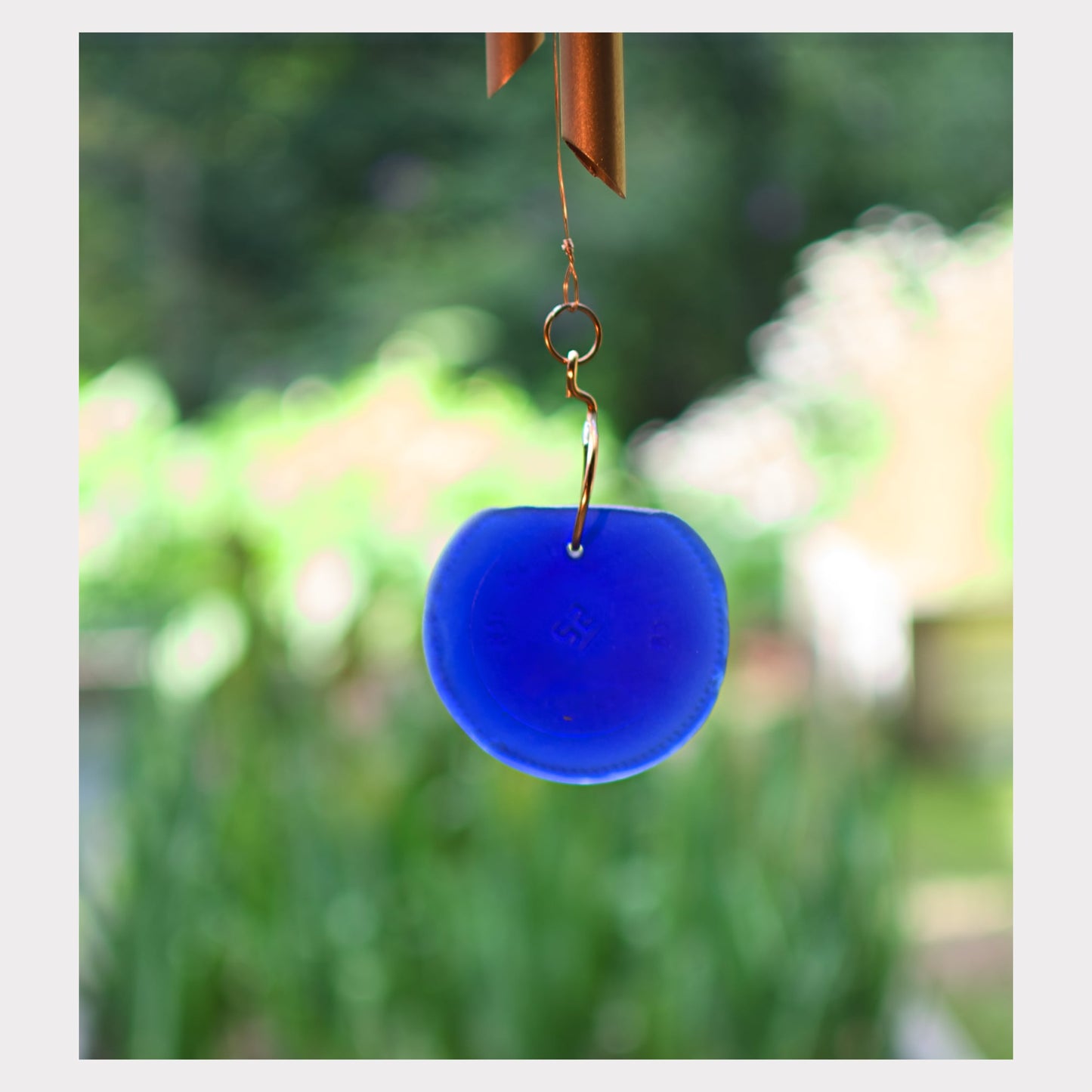 Detail, artist-made blue beach glass windsail for a large copper wind chime.