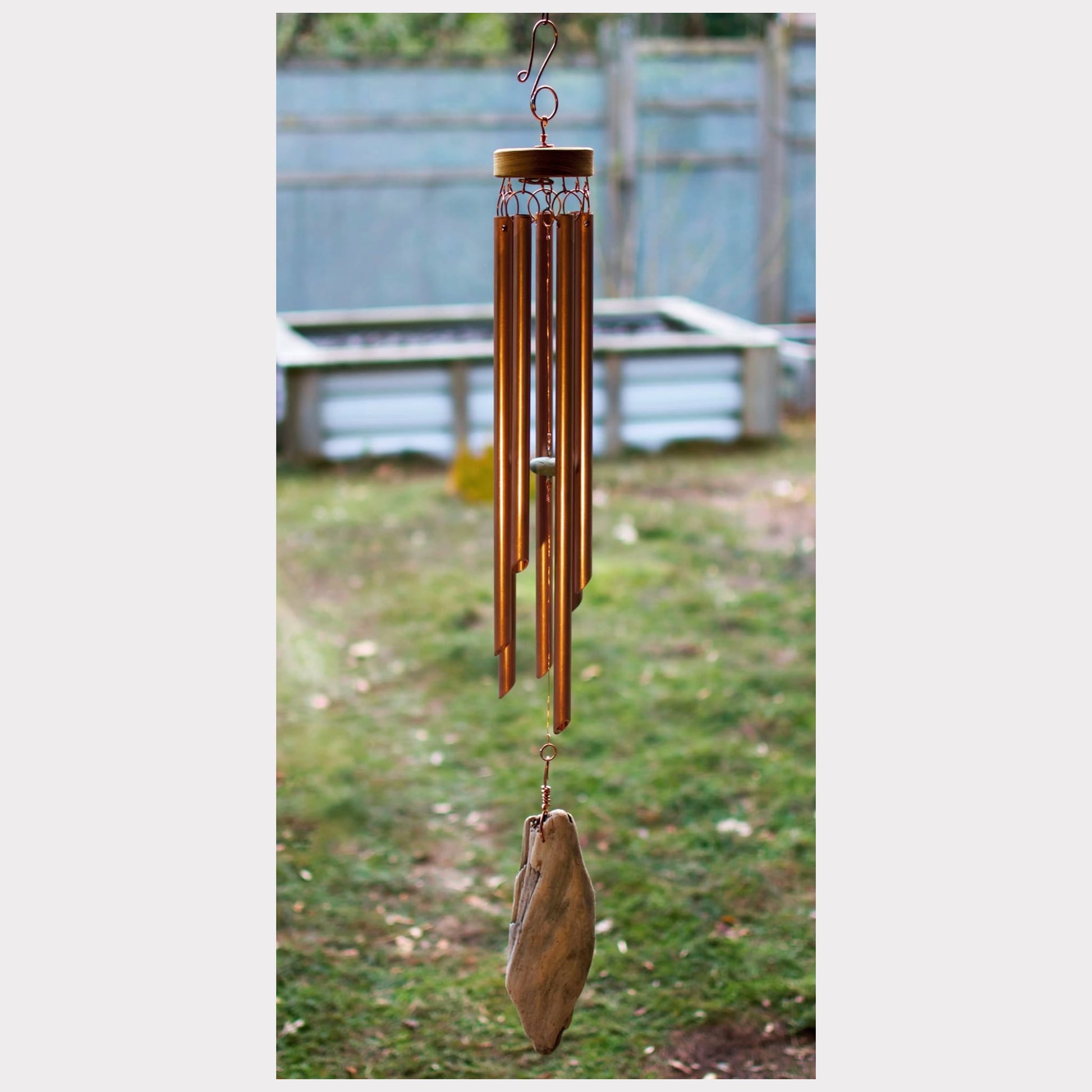 handcrafted rustic copper wind chime with a driftwood windsail.