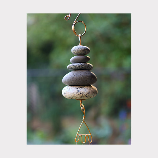 Detail, zen beach stone wind chime with five stones.