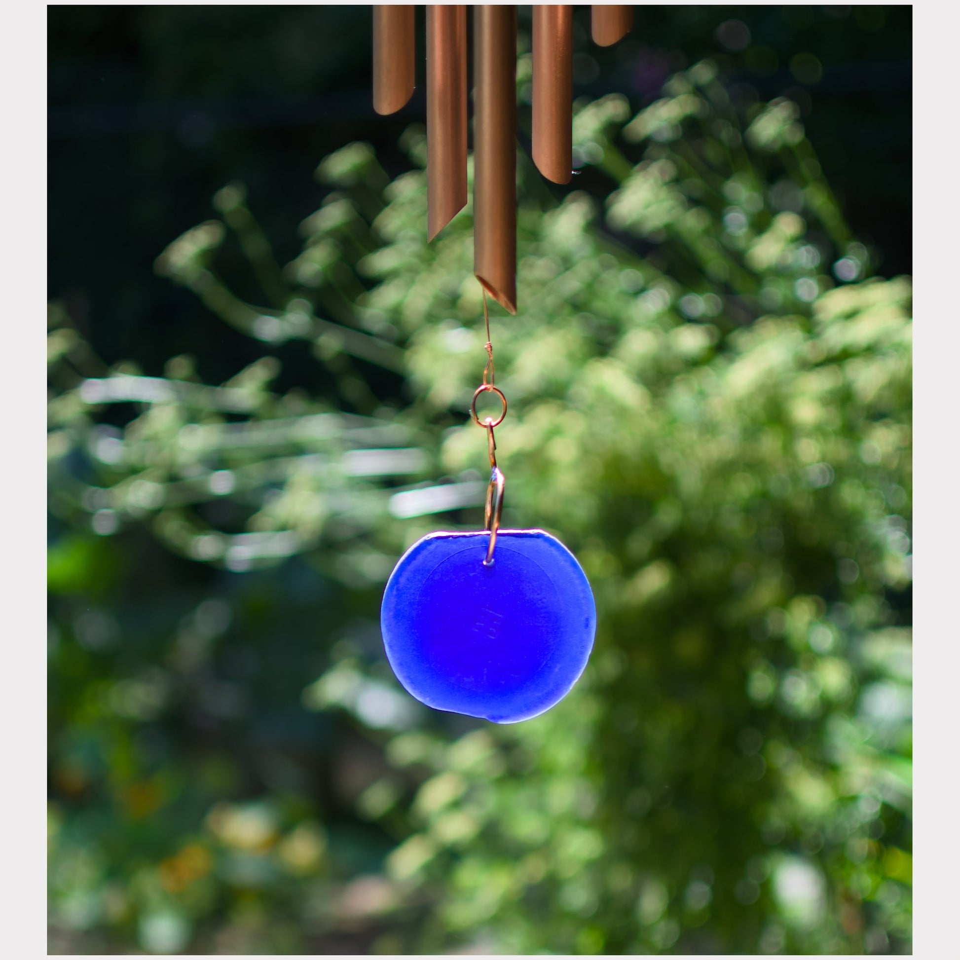Detail, artist-made beach glass windsail, cobalt blue, for a large copper wind chime.