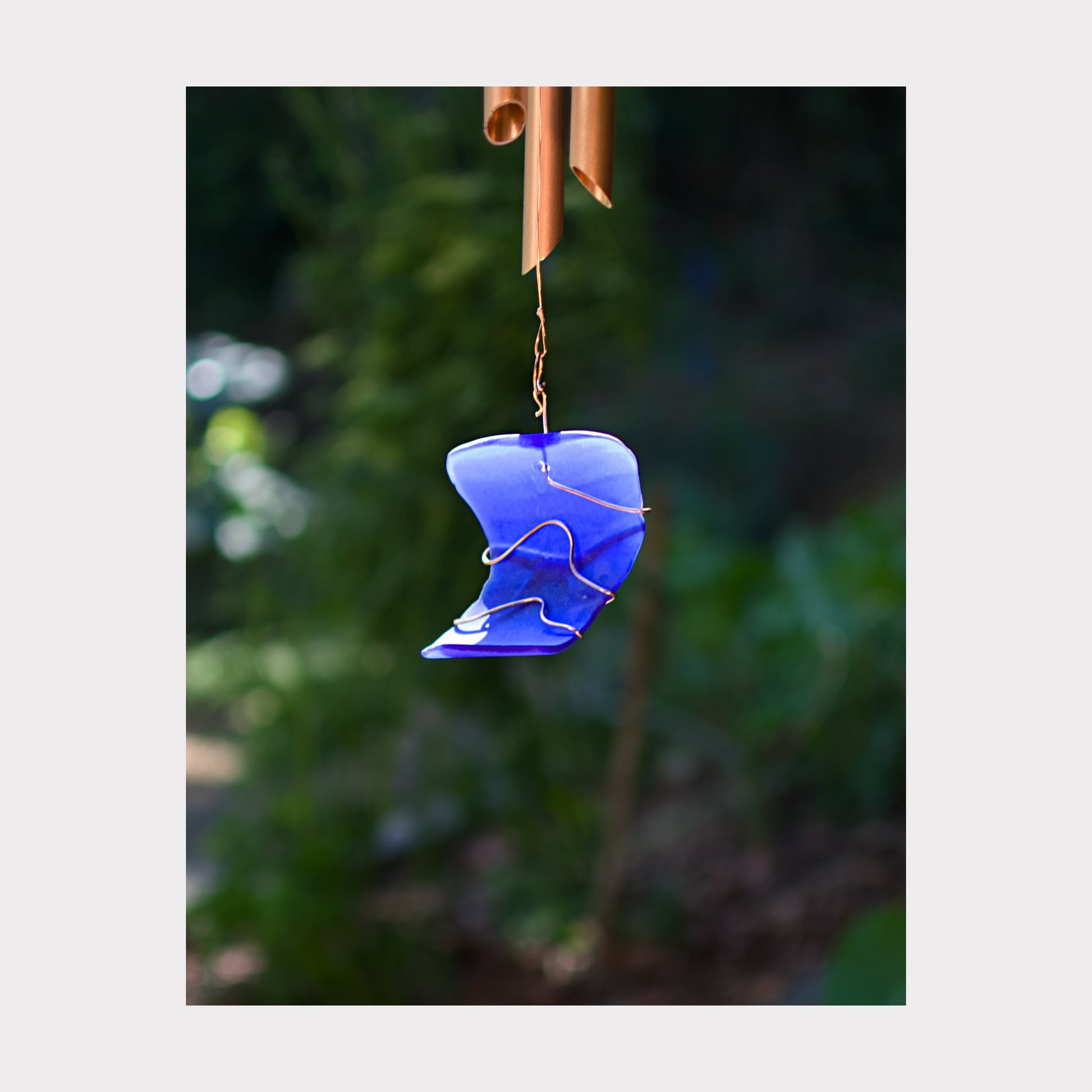 Detail, cobalt blue artist-made beach glass windsail for a large copper wind chime.
