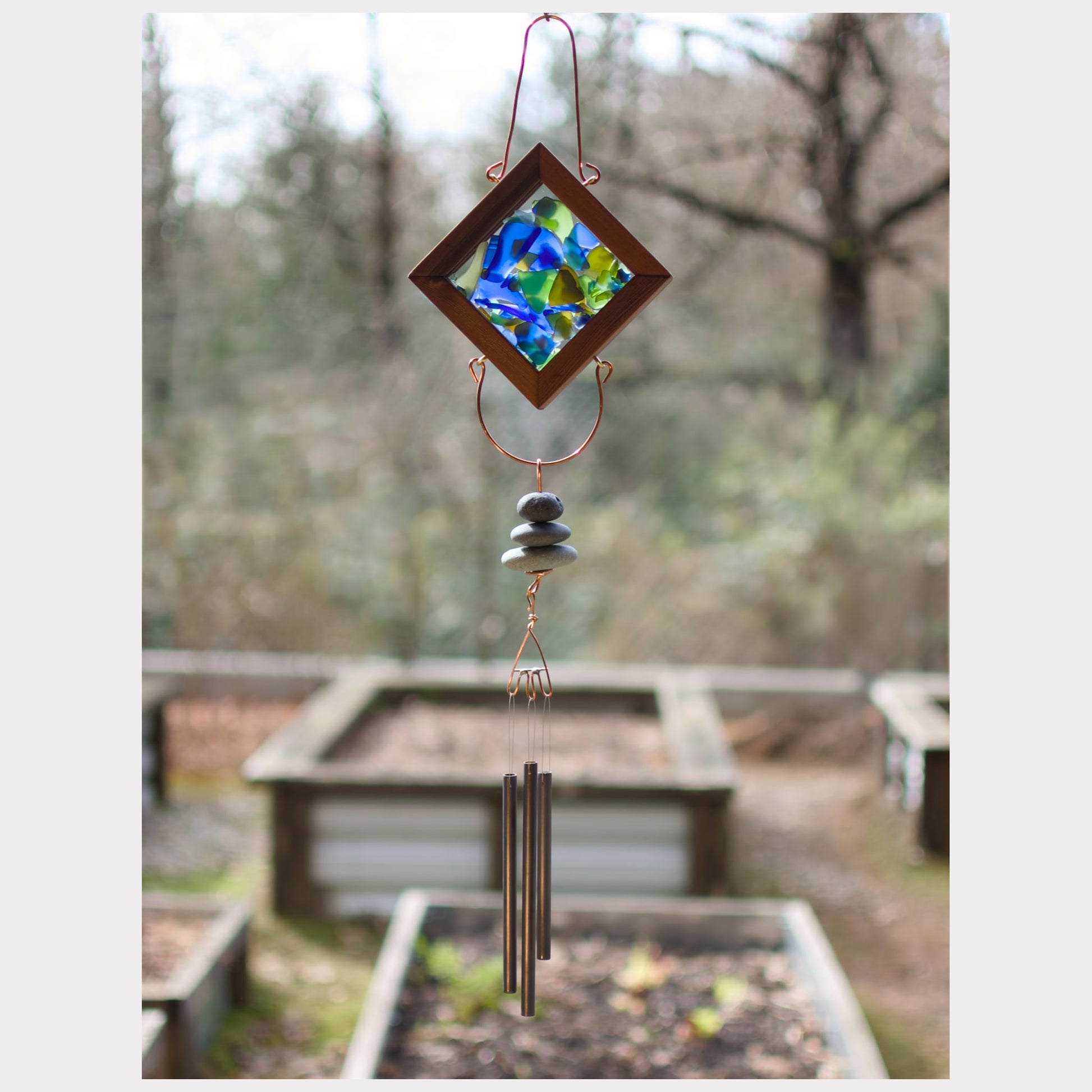 Kaleidoscope wind chime with three beach stones and three antiqued brass chimes.