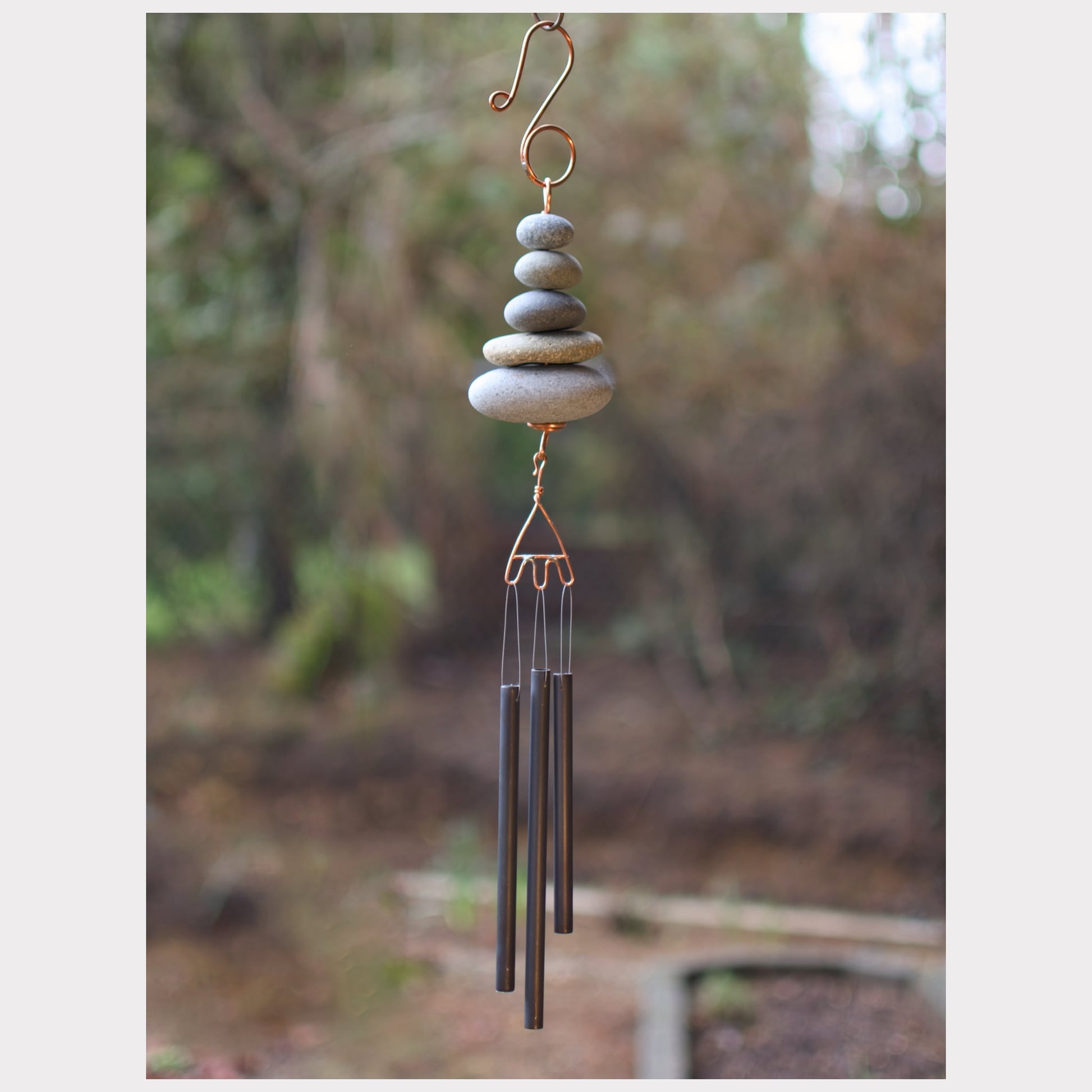 Zen wind chime featuring five beach stones and three antiqued brass chimes.