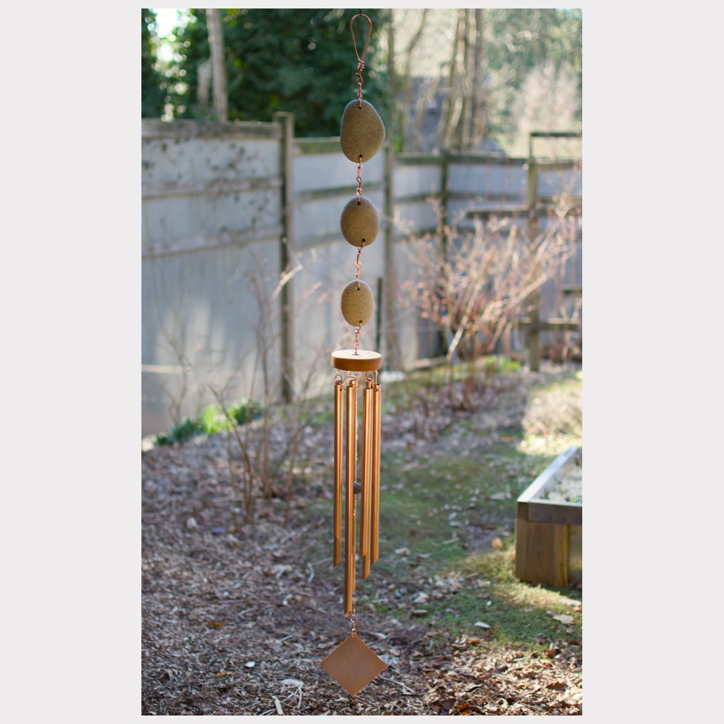 Large natural beach stone wind chime with seven copper chimes.
