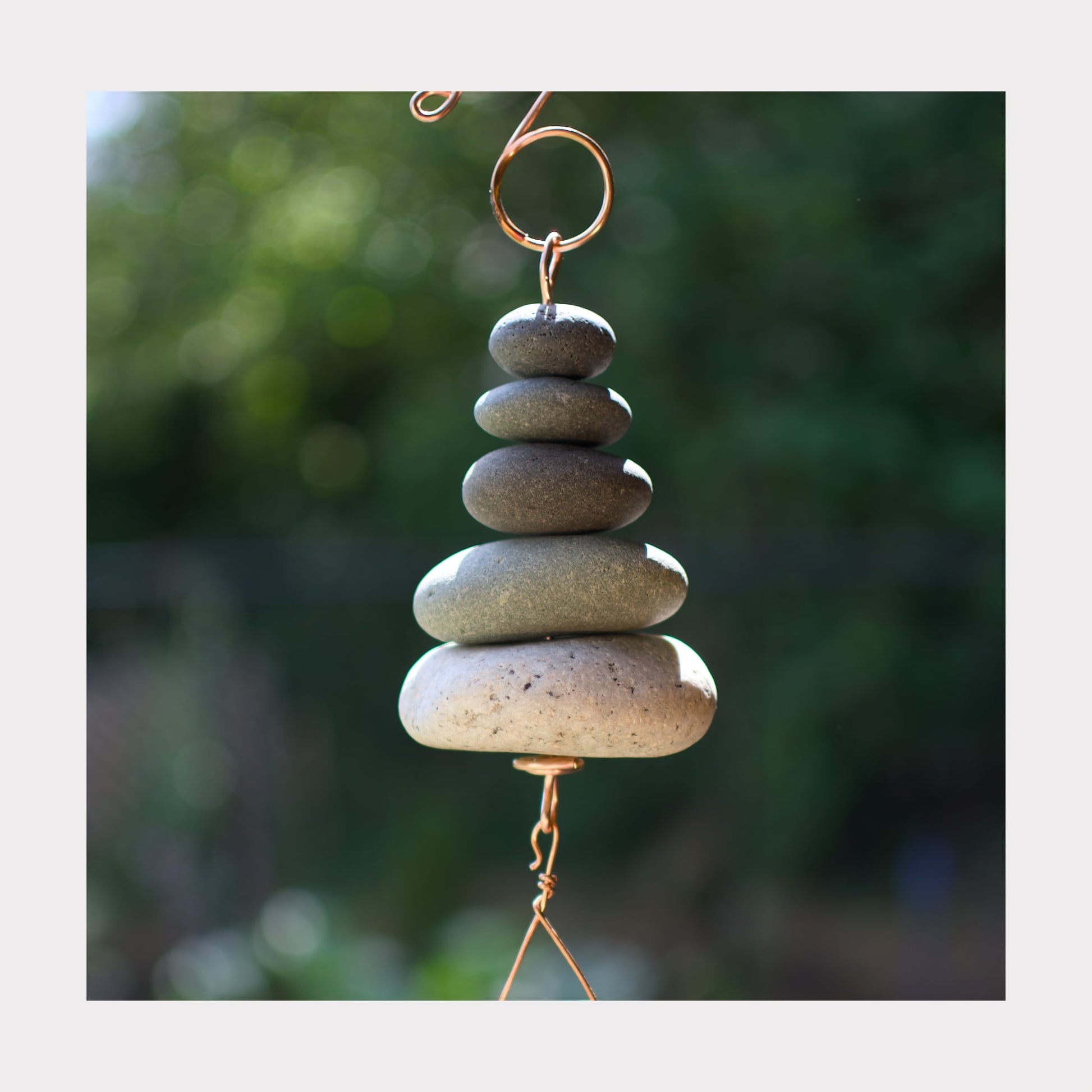 Detail, zen wind chime with beach stones.