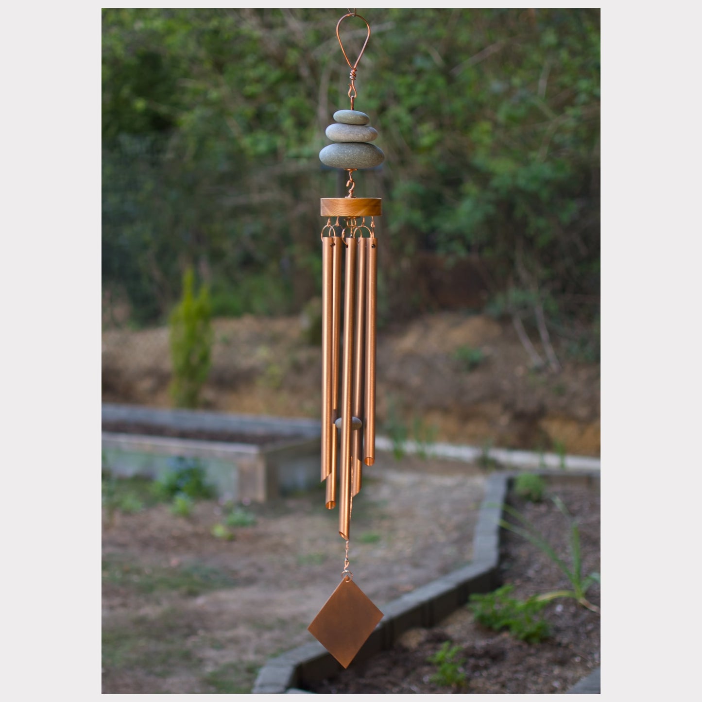 Zen wind chime featuring three natural beach stones and five genuine copper chimes.